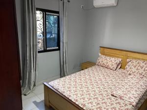 a bed in a room with a window and a bedspread at RESIDENCE ROYAL in Douala