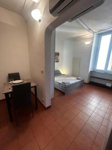 ジェノヴァにあるCasa Luccoliのベッド、テーブル、テーブル、椅子が備わる客室です。