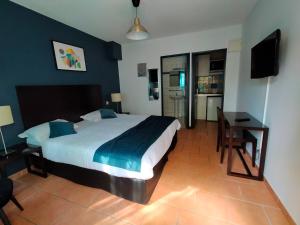 ein Schlafzimmer mit einem großen Bett und einem Schreibtisch in der Unterkunft Appart'Hotel Festival Sud Aqua - Avignon TGV in Avignon