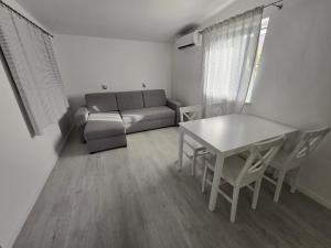 a living room with a table and a couch at Mała Wenecja - Apartament przy "Stodole" in Nowe Worowo
