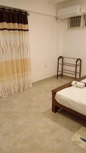 um quarto com uma cama e uma cortina num quarto em Sobasee Deluxe Bungalow em Kandy
