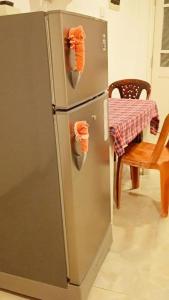 a stainless steel refrigerator in a kitchen with a table at Sobasee Deluxe Bungalow in Kandy