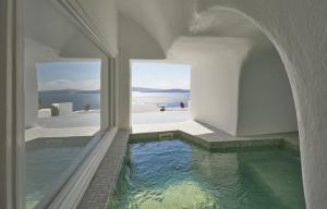 a pool of water in a room with a window at Diamond Luxury Suites Collection in Oia