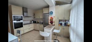 una cocina con electrodomésticos blancos y sillas blancas en Comme à la maison, en Llanes