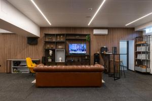 アヴェイロにあるHotel Afonso V & SPAのリビングルーム(革張りのソファ、テレビ付)