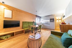 un soggiorno con divano e TV di Rienz Alpine City Suites a Brunico