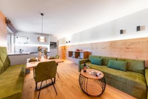 un soggiorno con divano e tavolo di Rienz Alpine City Suites a Brunico