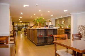 a restaurant with wooden counters and tables and chairs at Hotel Zé Maria in Pouso Alegre