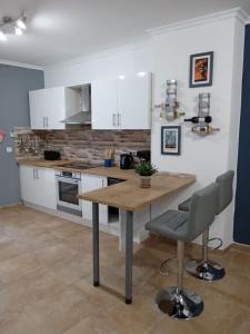 uma cozinha com armários brancos e uma mesa de madeira em Casa Elena em Orba