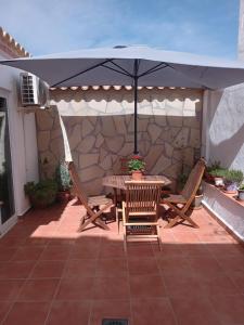 einen Tisch und Stühle unter einem Sonnenschirm auf einer Terrasse in der Unterkunft Casa Elena in Orba
