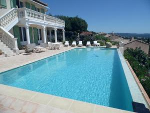 a large swimming pool in front of a house at La Bastide Fleurie rez de piscine in Cavalaire-sur-Mer