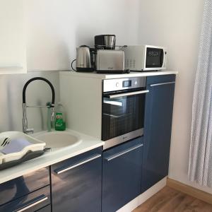a kitchen with a sink and a microwave at Ferienwohnung am Wald in Sebnitz