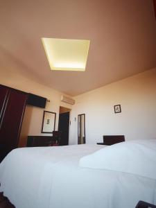 a bedroom with a white bed and a ceiling at Villa Hirschen in Zafferana Etnea