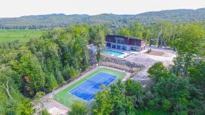 an aerial view of a house with a tennis court at Bel Air Tremblant Hotel & Residences in Mont-Tremblant