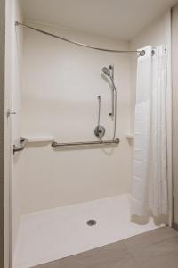 La salle de bains blanche est pourvue d'une douche avec rideau de douche. dans l'établissement Holiday Inn Express & Suites Englewood - Denver South, an IHG Hotel, à Englewood