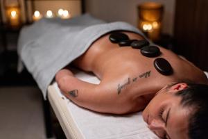 Ein Mann mit Perlen auf dem Rücken liegt auf einem Bett. in der Unterkunft Hotel Afonso V & SPA in Aveiro + 116 Fotos