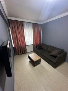 a living room with a couch and a television at URAZ Suit Otel in Bursa