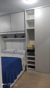 Dormitorio pequeño con cama y armarios blancos en Apt 2 qtos, prox. ao Rio centro, Jun, e P. Olimpic en Río de Janeiro