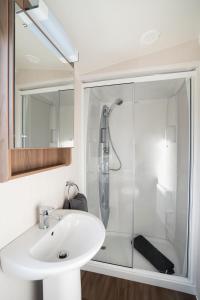ein Bad mit einer Dusche und einem Waschbecken in der Unterkunft BUNNY - 3 Bed Static Caravan in Port Seton