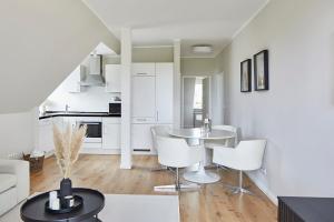 kuchnia i salon ze stołem i krzesłami w obiekcie Techts Landhus Birkenallee w mieście Timmendorfer Strand