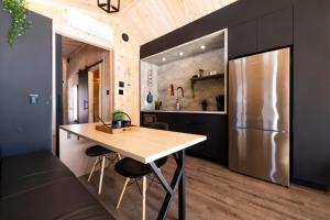 a kitchen with a wooden table and a refrigerator at Le Versant Mont-Sainte-Anne in Saint-Férréol-les-Neiges