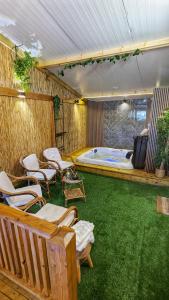 um quarto com uma banheira com cadeiras e uma televisão em bali carmel zimmer & spa em Dāliyat el Karmil