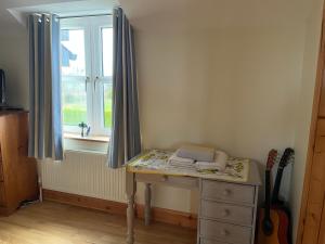 a room with a dresser and a window with a desk at Adrigoole in Waterford