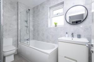 a bathroom with a sink toilet and a mirror at Leeds 3 Bed - Parking, Self Check-in, En-suite, WiFi, Fussball, Garden - Groups, Contractors, Families, Long Stays - Alt-Stay in Bramley