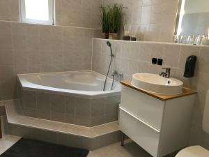 a bathroom with a tub and a sink at Ferienwohnung am Wald in Sebnitz +24 photos