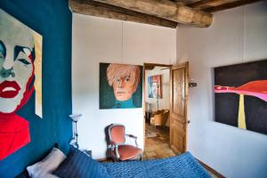 - une chambre avec un lit bleu et des peintures sur les murs dans l'établissement Chambre d'Hôte vue exepitonnelle, à Uzès