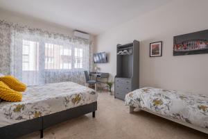 a bedroom with two beds and a desk at San Pietro Dream House in Rome