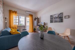 sala de estar con mesa y sofá azul en San Pietro Dream House, en Roma