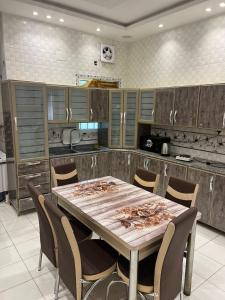 a large kitchen with a wooden table and chairs at Dar Al Karama Residential Units in AlUla