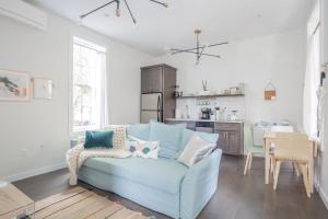 a living room with a blue couch and a kitchen at Pastel Paradise - Adorable Covington Apartment in Covington