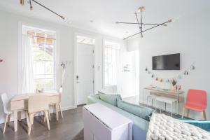 Pastel Paradise - Adorable Covington Apartment في كوفينغتون: غرفة معيشة مع أريكة زرقاء وطاولة