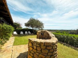 a stone fireplace in the yard of a house at Villa Erika Is Molas mare golf in Pula