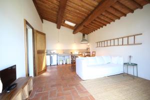 a living room with a white couch and a kitchen at Marrucheti 82 in Campagnatico