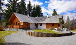 a log cabin with a driveway in front of it at Alpine Retreat Apartments Šurc in Rateče