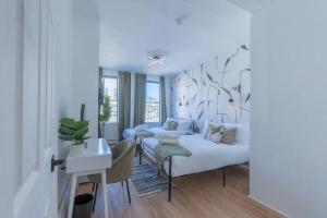 a white bedroom with a bed and a desk and a desk at Posh Suite with 2 Queen Beds, Full Kitchen, Sleeps 6, by Train, 15 min to NYC in Hoboken