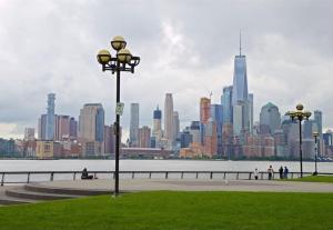 a park with a view of a large city at Posh Suite with 2 Queen Beds, Full Kitchen, Sleeps 6, by Train, 15 min to NYC in Hoboken