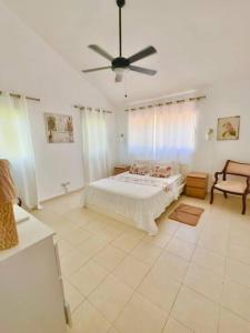 a bedroom with a bed and a ceiling fan at Villa Grupal en Metro Country Club. in La Fe