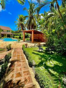 a garden with a stone path leading to a house at Villa Grupal en Metro Country Club. in La Fe