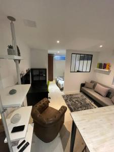 ein Wohnzimmer mit einem Sofa und einem Tisch in der Unterkunft Studio industriel loft neuf avec parking privé in Reichstett