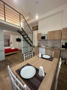 eine Küche und ein Esszimmer mit einem Tisch und einer Treppe in der Unterkunft Amore e Psiche in Scilla