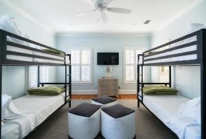 two bunk beds in a room with a tv at Church St Collection - 109 Whole House and Pool in Fairhope