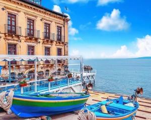 a boat parked next to a building next to the water at Amore e Psiche in Scilla +16 photos