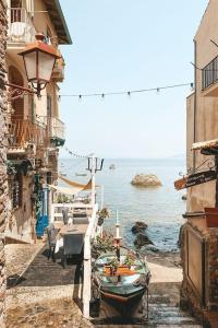 a group of buildings with boats on a street next to the ocean at Amore e Psiche in Scilla