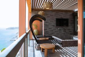 einen Balkon mit einer Badewanne, einem Stuhl und einem Tisch in der Unterkunft Pullman Dakar Teranga in Dakar