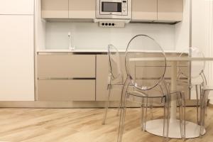 a glass table and two chairs in a kitchen at La Casa Del Molo in Finale Ligure +19 photos
