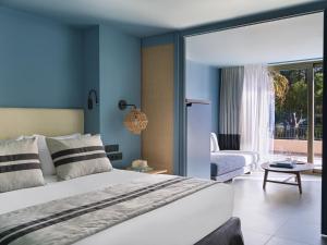 a bedroom with a large bed and a living room at Kalamaki Beach Resort in Isthmia